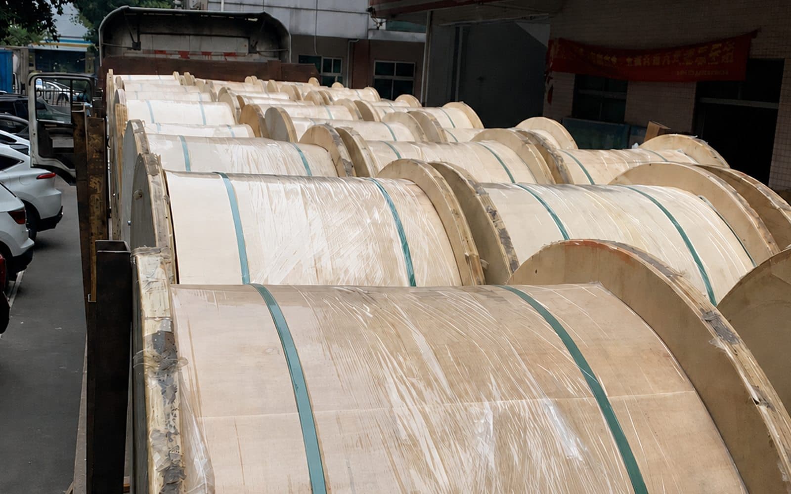 Wrapped wooden fiber optic cable drums loaded for factory dispatch